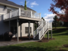 Light grey second story deck with stairs and white banister