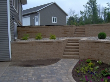 Dual level tan brick retaining wall with rock garden