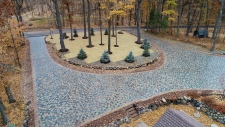 Blue and red stone semi-circle driveway with trees in center